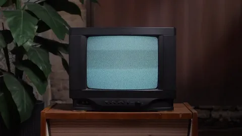 An old-style television set displaying static on the screen, symbolizing a smart TV that is stuck on a frozen or black screen due to a software or firmware glitch.