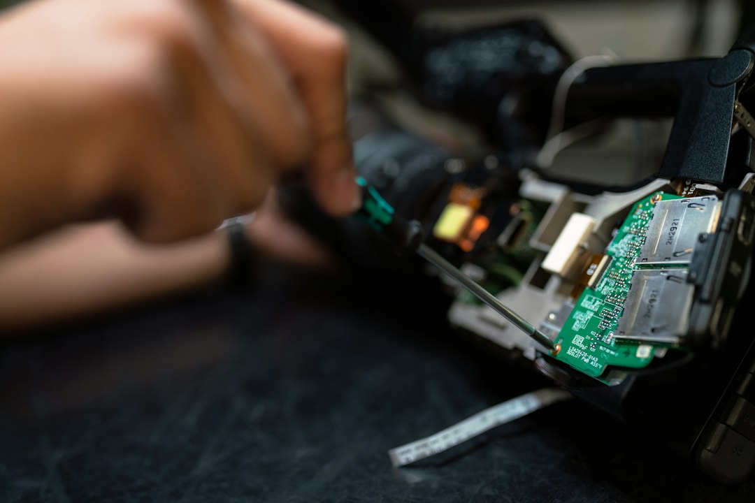 Technician holding an electronic circuit board during electronic repair near me in Dubai